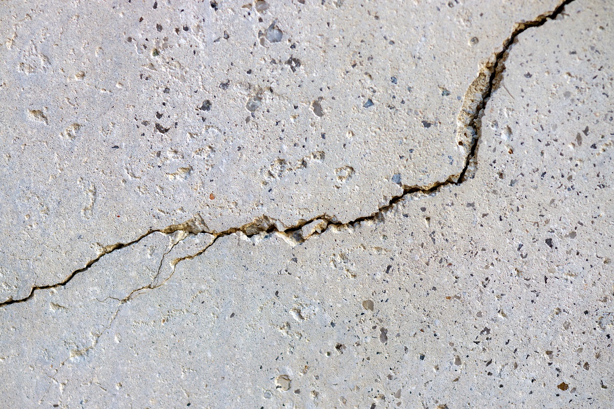 Cracked concrete wall in a gray color.