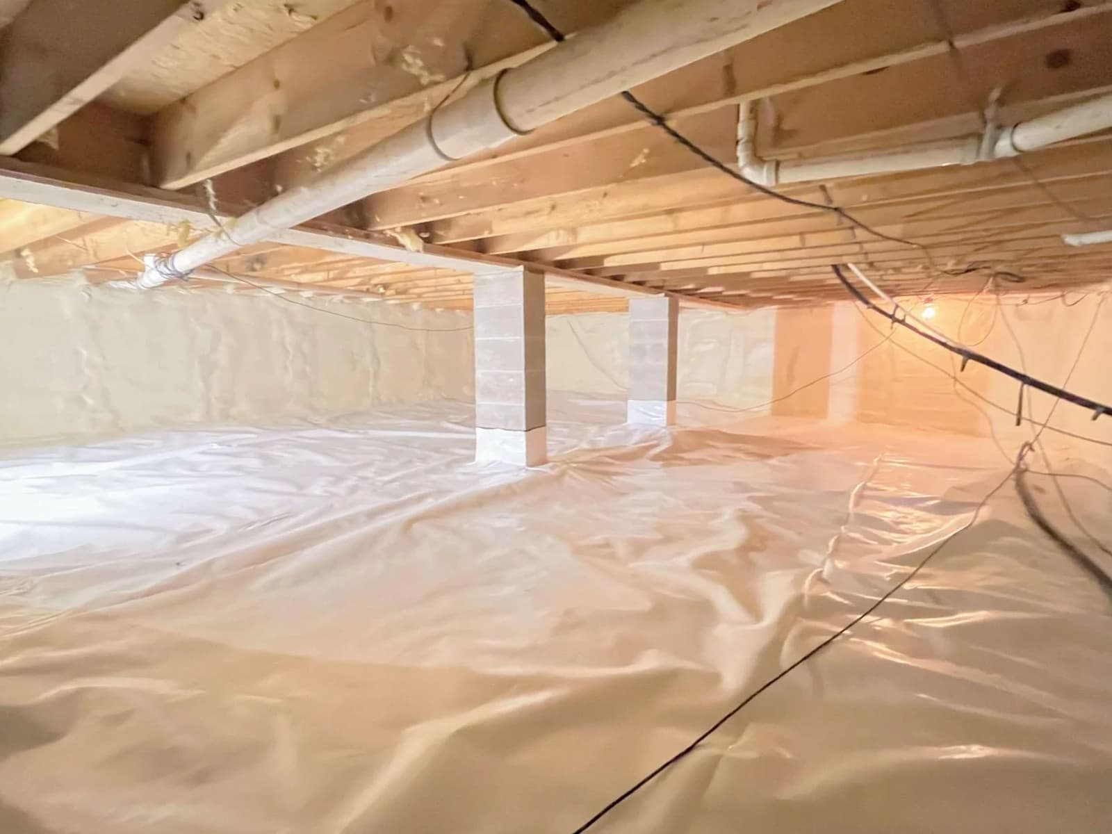 Fully encapsulated crawl space with a sealed liner on the floor and walls in an Ontario home.