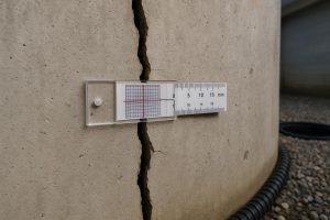 Crack monitor gauge measuring a widening vertical foundation wall crack