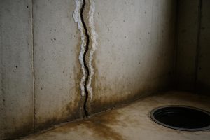 Vertical crack with moisture staining on a Hamilton poured concrete basement wall